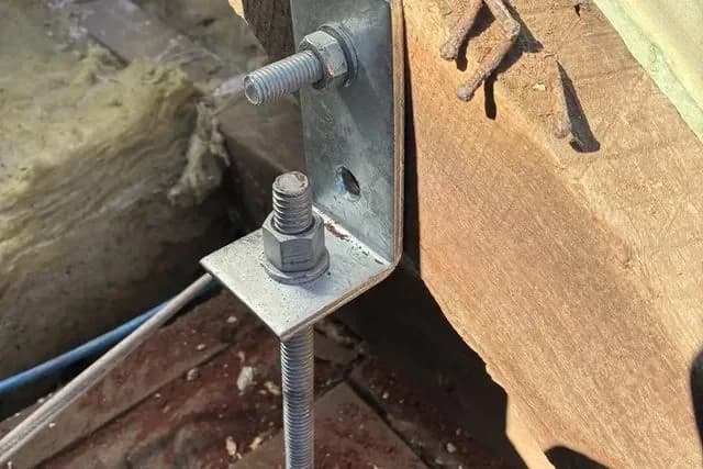 A new galvanised bracket bolted to roof timbers